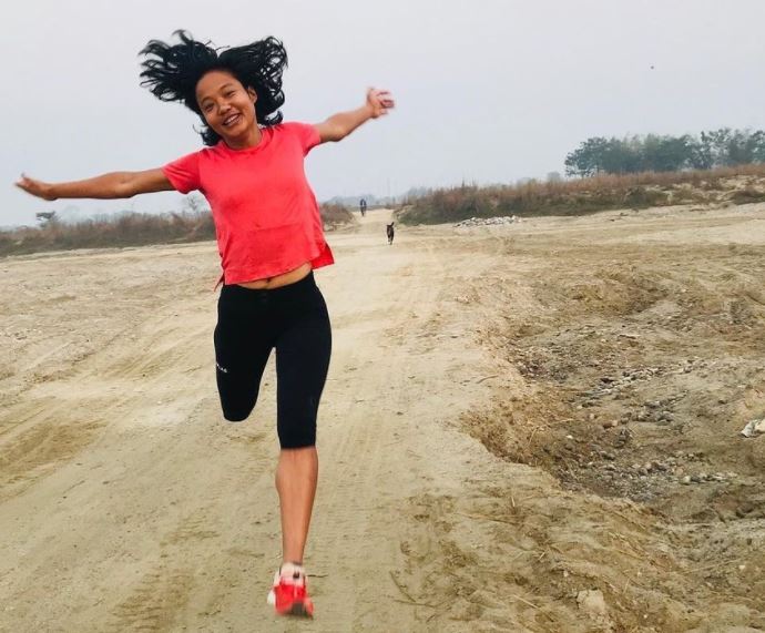 Photo of Mira Rai running with arms outstretched